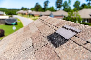 Missing shingles on roof due to storm damage.